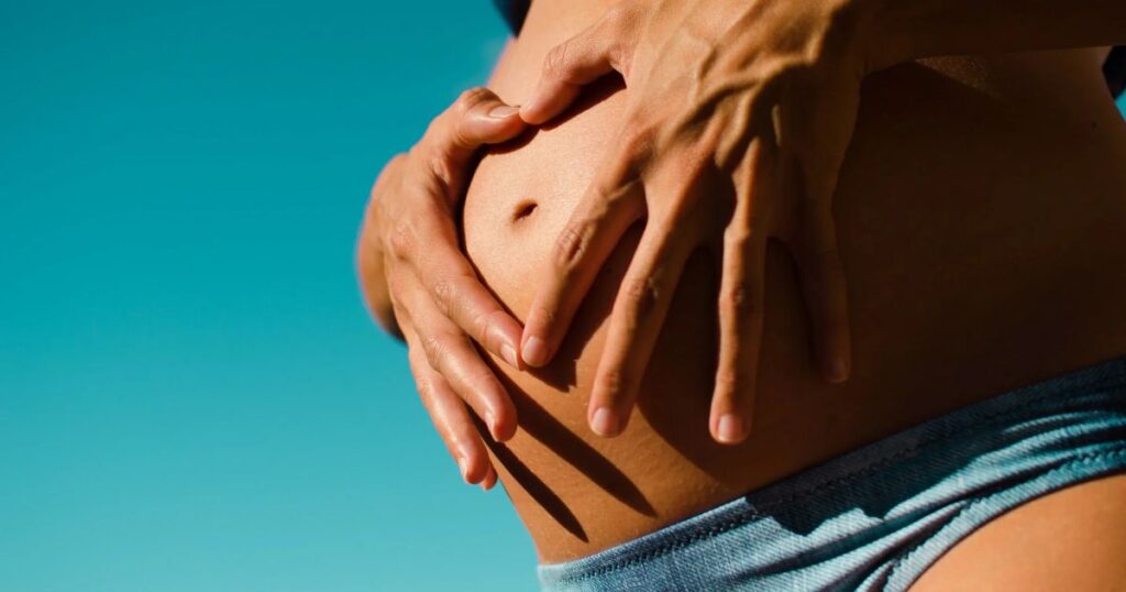 pregnant belly with hands making heart shape