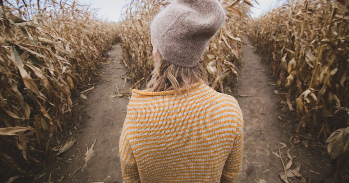 woman in corn maze choosing path