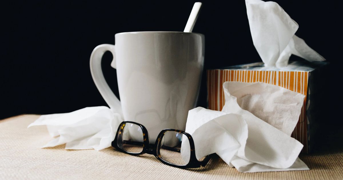 box of kleenex and hot tea by bedside