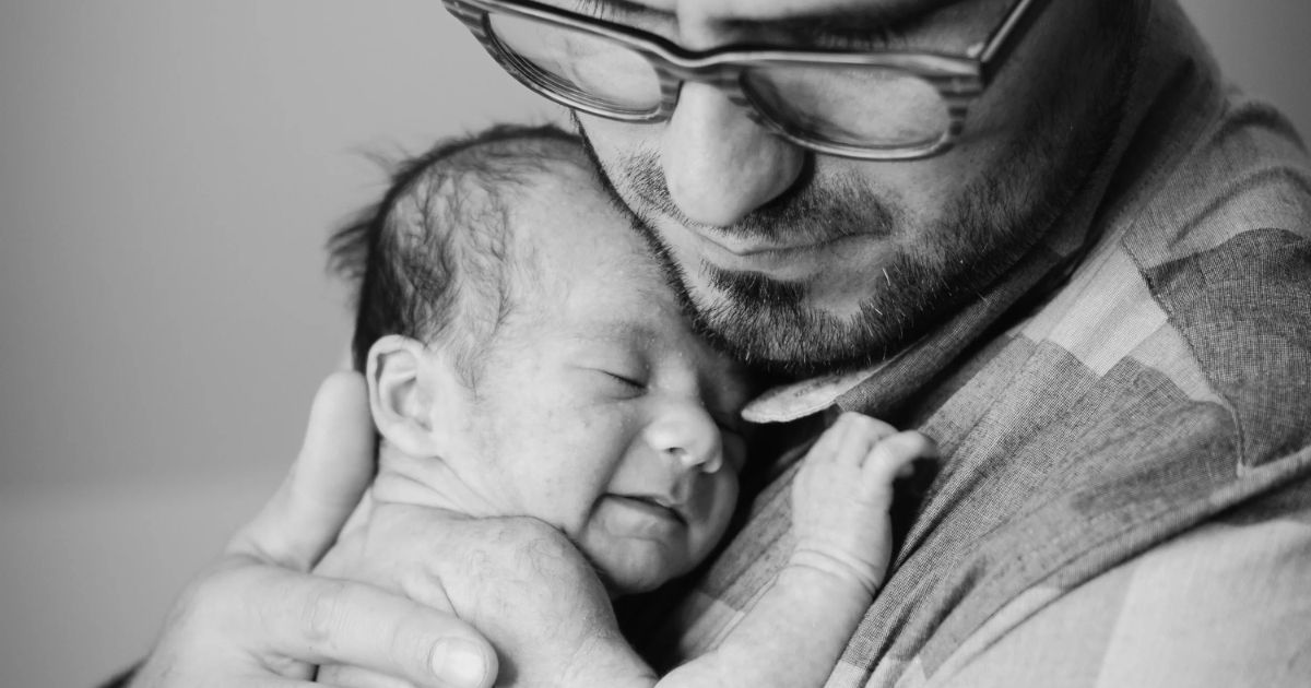 new dad holding newborn baby