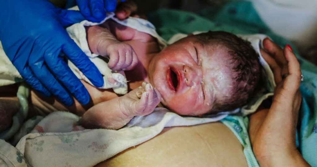 newborn baby at birth in the golden hour