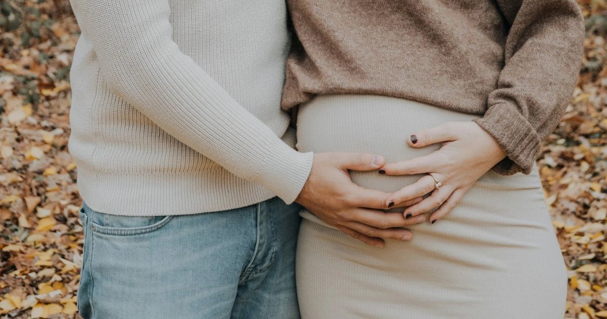 pregnant couple with hands on the belly