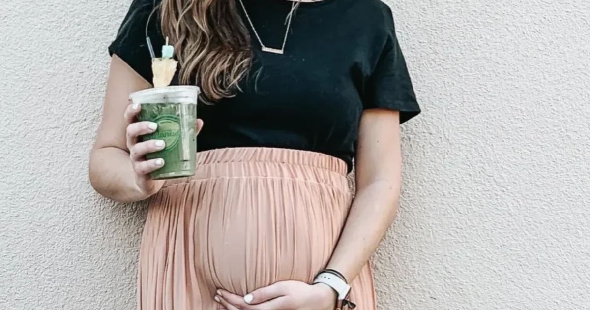pregnant woman holding green smoothie