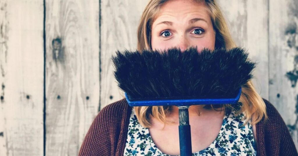 woman holding push broom