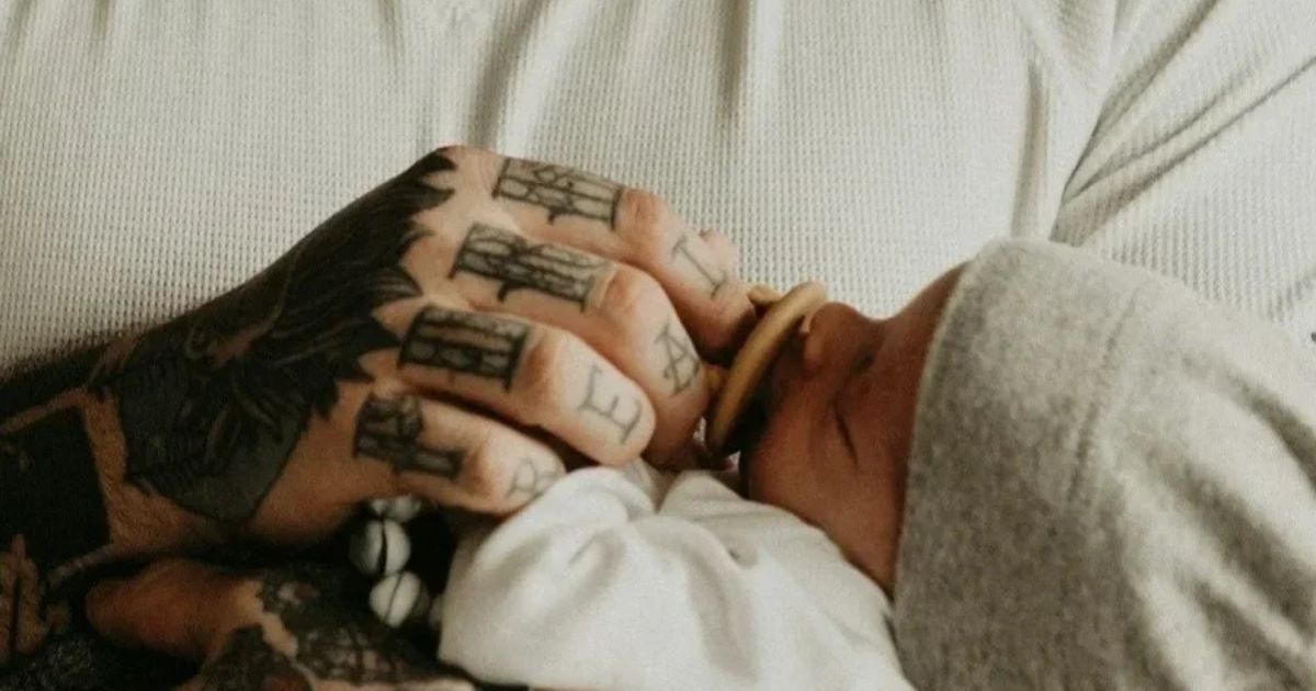 new dad holds baby with pacifier