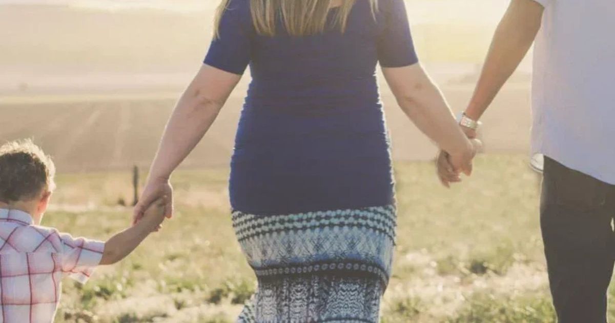 family holding hands field