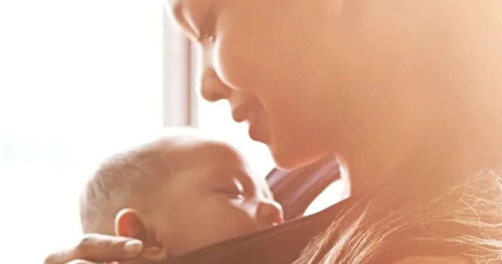 new mom holding baby in sling