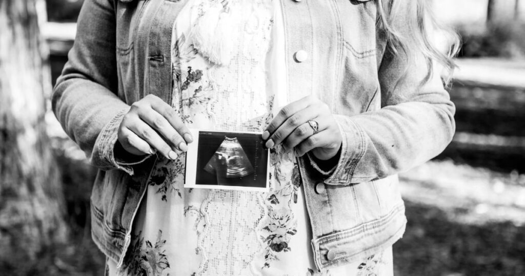 pregnant woman holding ultrasound image